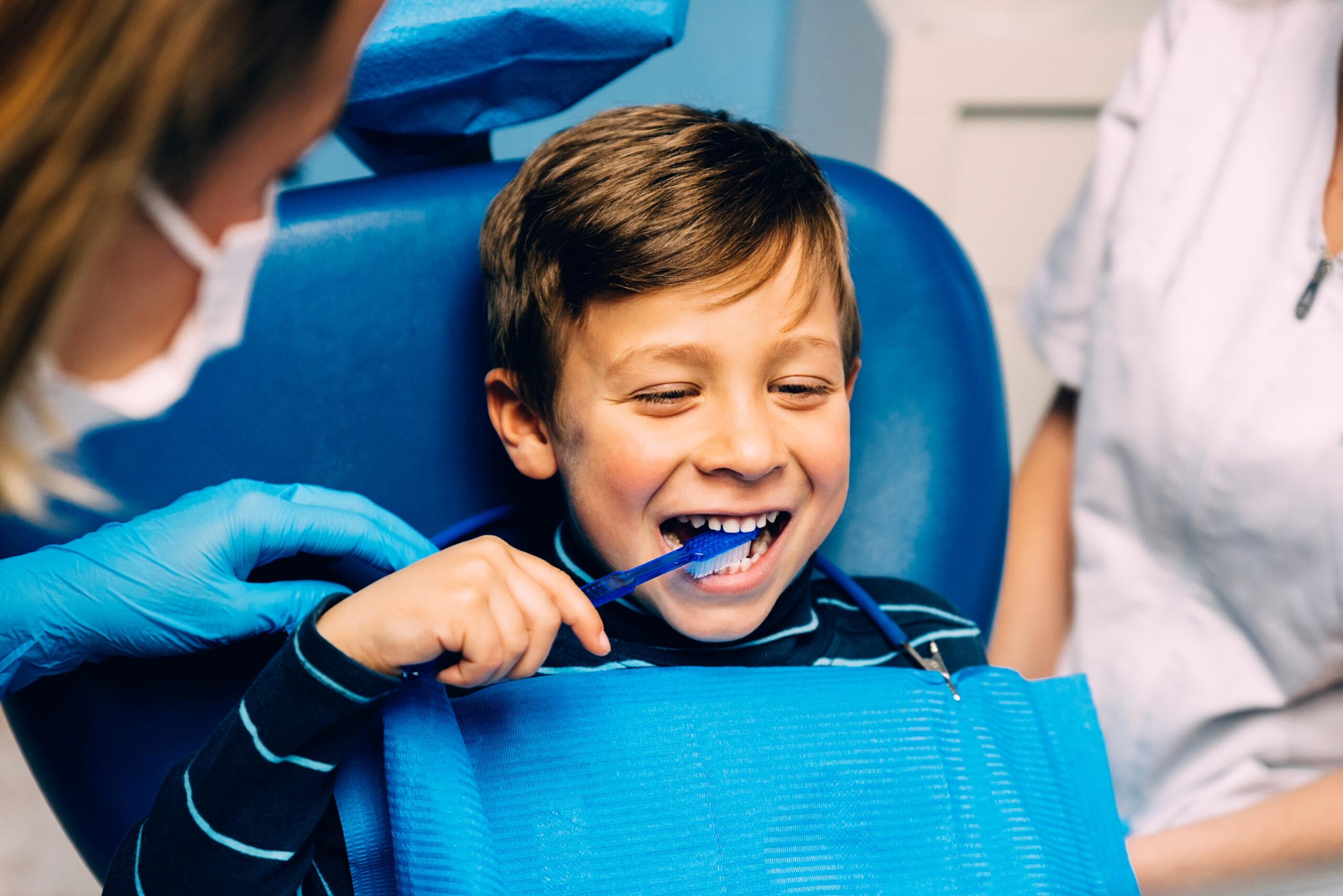 Young boy learns how to properly brush and floss at The Center of Dentistry
